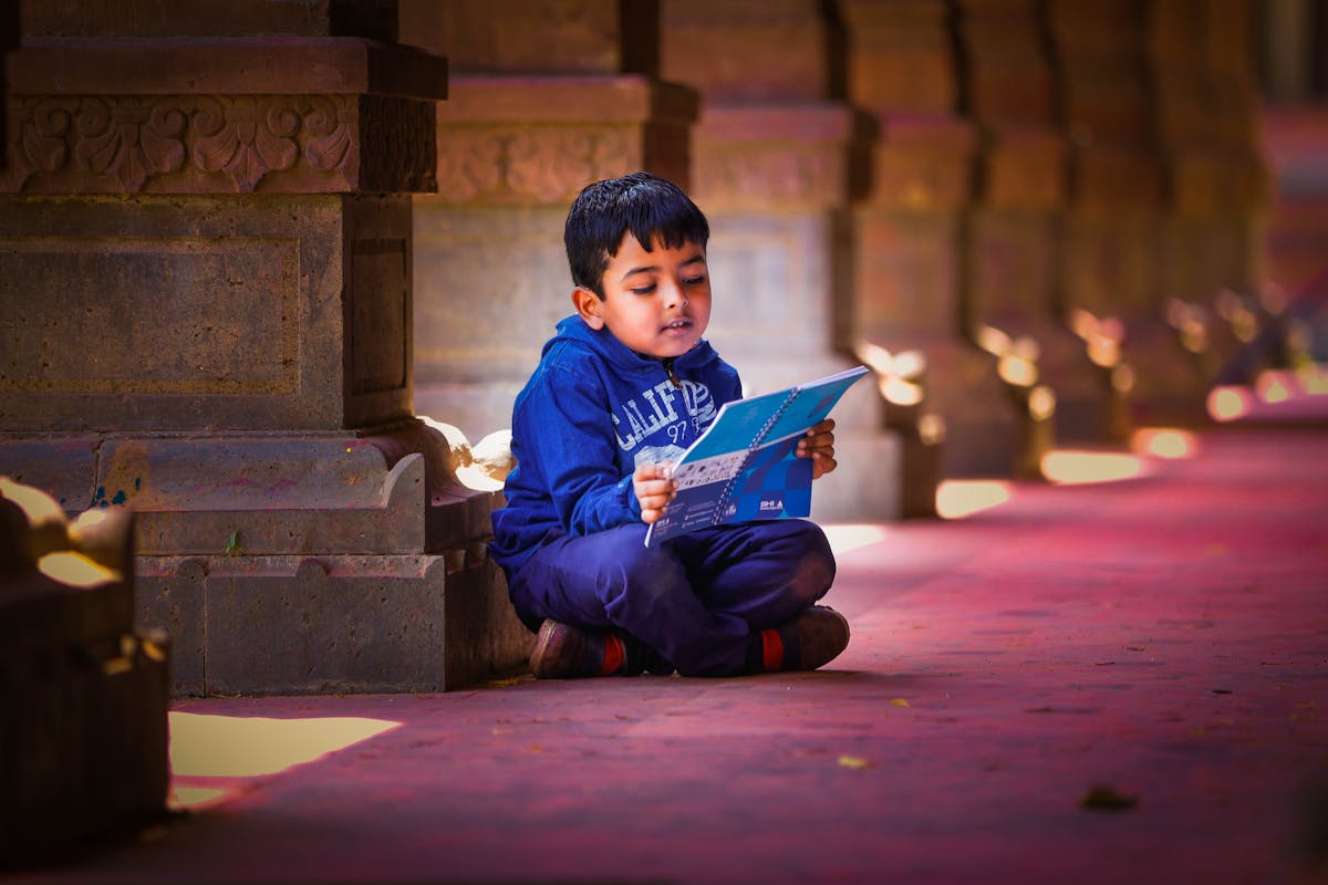 A child quietly absorbed in reading, supported by the Triumph Foundation Autism Centre